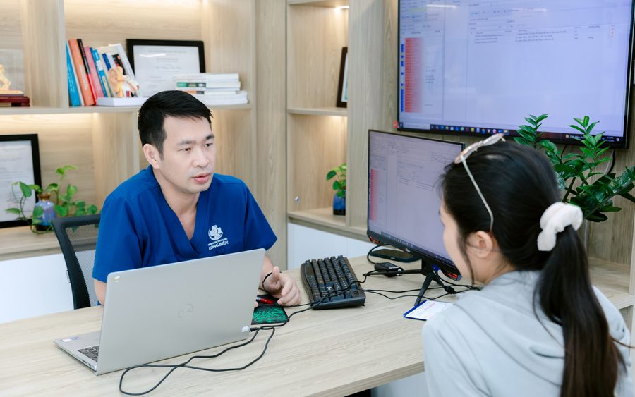ThS.BS Phùng Tiến Hiệu tại bàn khám, phía sau là tủ bằng cấp và huy chương chuyên môn