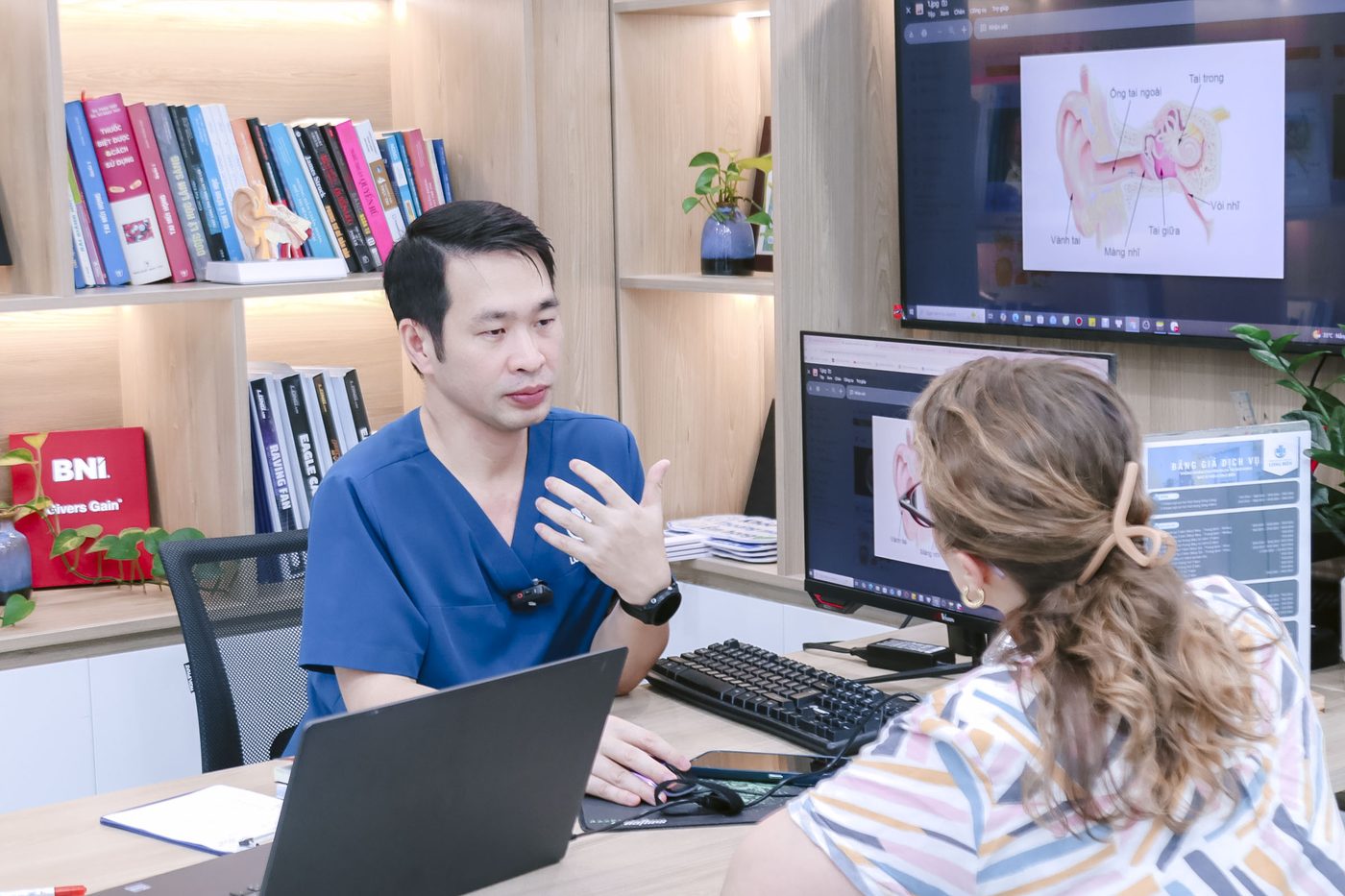 Bác sĩ Hiệu giải thích tình trạng bệnh cho khách qua hình ảnh giải phẫu