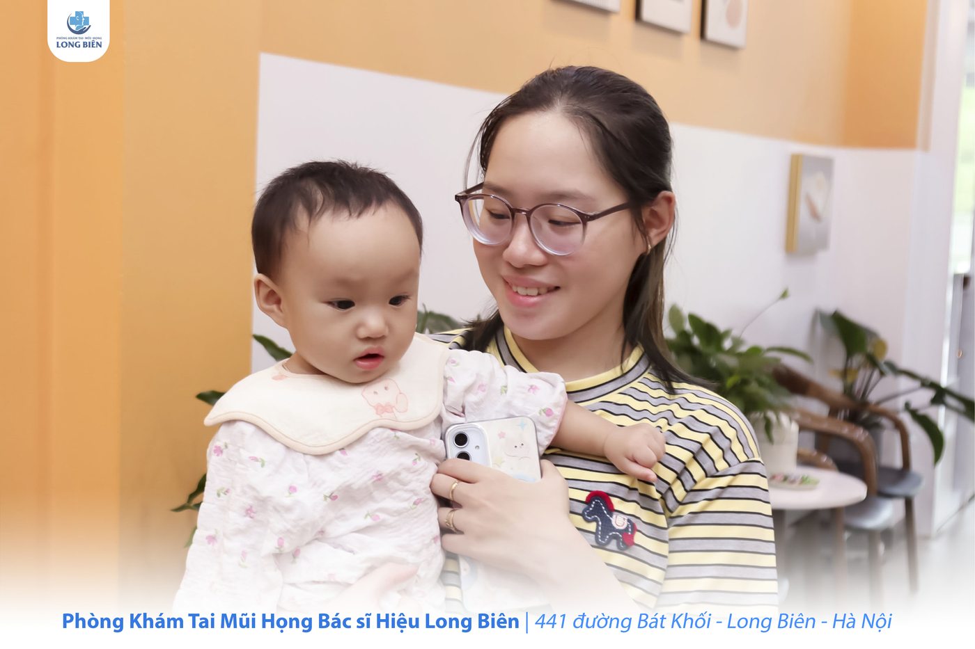 Người mẹ bế con nhỏ tại Phòng khám TMH Bác sĩ Hiệu Long Biên