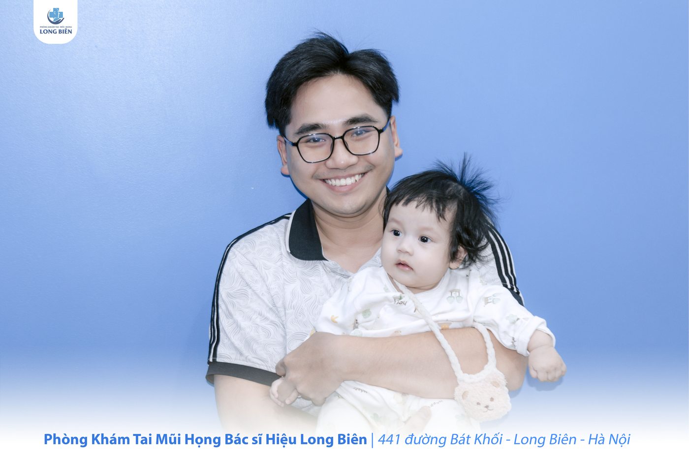 Người cha bế con nhỏ tại Phòng khám TMH Bác sĩ Hiệu Long Biên