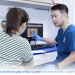 Bác sĩ Hiệu dùng sơ đồ giải phẫu tai giải thích cơ chế viêm tai giữa cho phụ huynh