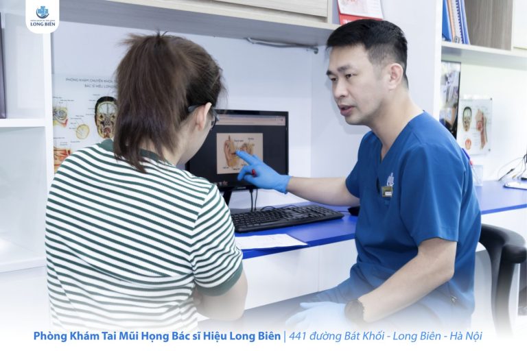 Bác sĩ Hiệu dùng sơ đồ giải phẫu tai giải thích cơ chế viêm tai giữa cho phụ huynh